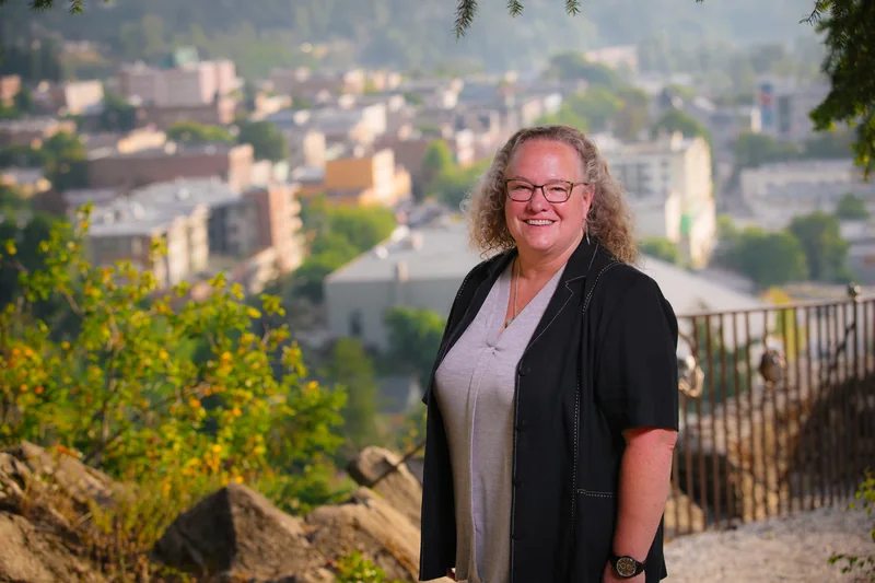 Janice Morrison at a lookout above downtown Nelson, with a railing beside her.